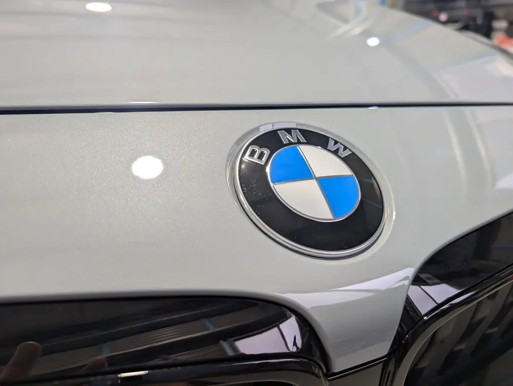Close-up of a BMW badge on glossy white paintwork