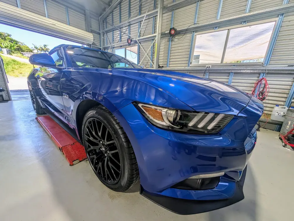 Blue coupe in a detailing bay with a glossy finish