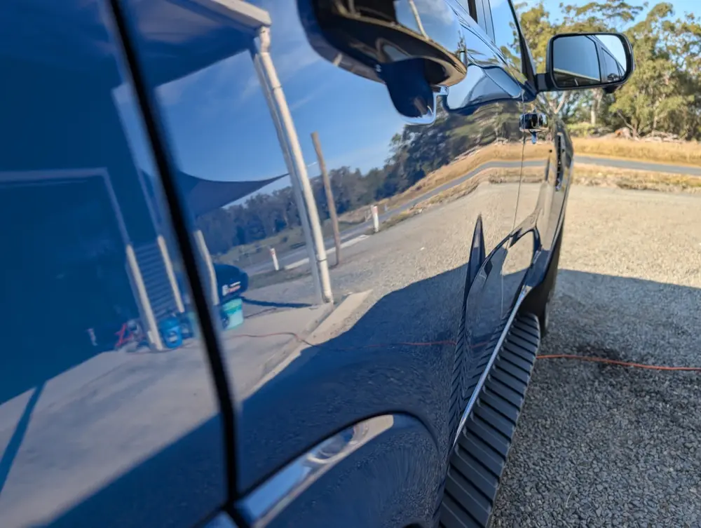 Reflection visible across a polished blue vehicle panel